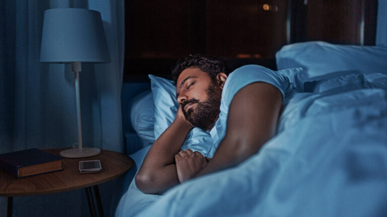 indian man sleeping in bed at home at night